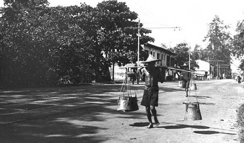 Night Soil Man - When full, a night soil man collected the buckets to dispose of their contents  Courtesy of National Archives of Singapore