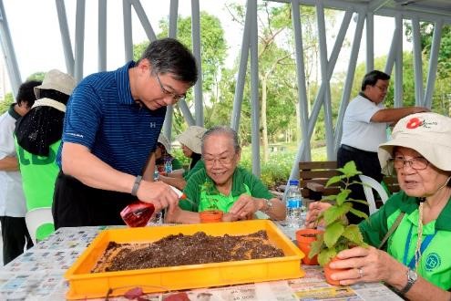 Minister Gan Kim Yong joining participants from Lions Befrienders in a planting activity