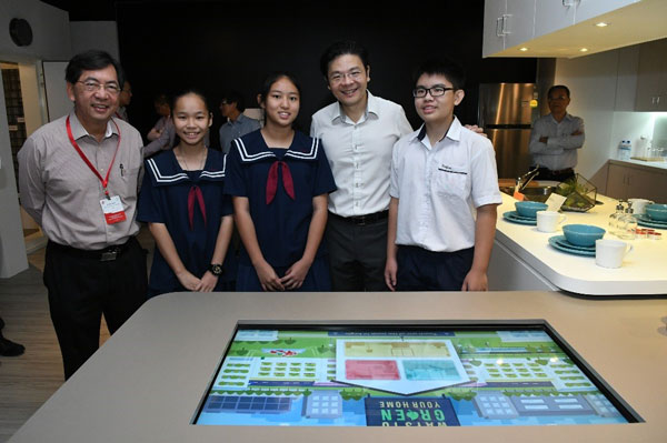 BCA CEO Dr John Keung (first from left) and Minister Lawrence Wong (fourth from left), with students from Woodgrove Secondary School, at the showflat exhibit.