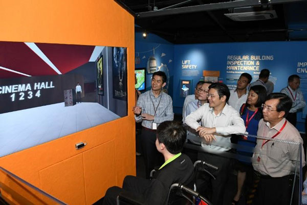 Minister Lawrence Wong and BCA CEO Dr John Keung checking out a demonstration of the Wheelchair Interactive exhibit.