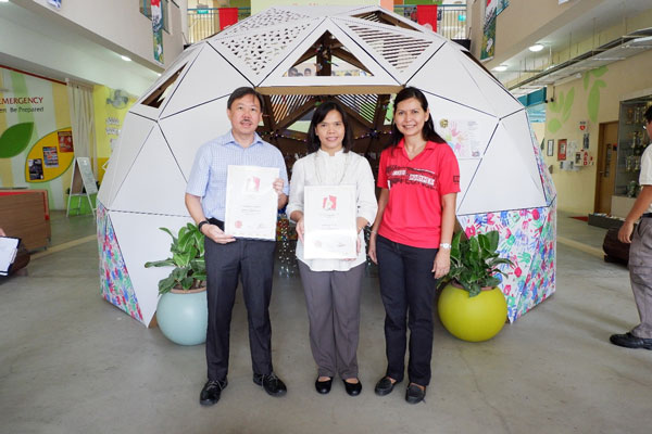 An official from the Singapore Book of Records (right) presents certificates for the record-breaking achievement to BCA CEO Mr Hugh Lim (left) and APSN DSS principal Mdm Aslinah bte Ahmad (centre).