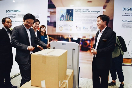 Minister Wong (left) looking at how robots can be deployed for night deliveries.